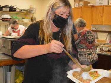 Carol Casselman adds the finishing touch to a turkey dinner as volunteers from King's Kitchen and Royal Canadian Legion Fort Wellington Branch 97 deliver Christmas cheer to about 175 people in the South Grenville area on Saturday.
Tim Ruhnke/The Recorder and Times