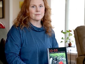 Retired RCMP officer Laurie White holds a copy of her book, 10-33: An Officer Down Steps Back Up. (RONALD ZAJAC/The Recorder and Times)