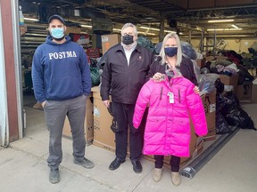 Caleb Postma (left), owner of Postma Heating and Cooling, is with Stephan Holland and Allie Matthews, from the Salvation Army Chatham-Kent Ministries, with the 986 coats that were collected for Operation Cover-Up. Handout