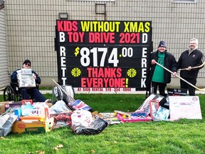 Chatham brothers Brett and Derek Gore presented $8,174 in toys to Salvation Army Chatham-Kent Ministries to Cpt. Steve Holland, right. The brothers collect bottles and cans throughout and use the money to purchase toys for children without Christmas.