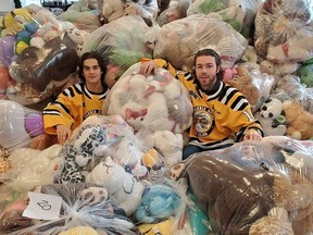 Sarnia Sting forward and 2021 Teddy Bear Toss goal scorer Nolan Burke and Sarnia Sting Captain Brayden Guy pose with some of the over 5,000 stuffed toys donated to the Sting's 24th annual Teddy Bear Toss, sponsored by Lambton Ford.  Handout/Sarnia This Week
