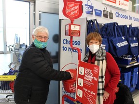 In this file photo, Cheryl Lambe, left, of Chatham donates to the Red Kettle campaign of the Chatham-Kent Salvation Army on Dec. 23, 2021. She's shown with volunteer Cathie Weir, who was stationed at a kettle at the Real Canadian Superstore. (Ellwood Shreve/Chatham Daily News)