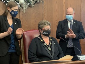 Coun. Stephanie Jaworski, left, and Coun. Tony Fraser, right, clap after walking Warden Carma Williams, centre, to her chair at the head of SDG council on Friday, Dec. 17. Handout/Cornwall Standard-Freeholder/Postmedia Network