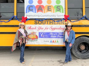 Cochrane Lions Rodeo Queen Breanna Corriea and Miss Rodeo Canada Jayden Calvert with the bus designated for toys (there was another for food) at the Stuff-a-Bus event in front of Canadian Tire on December 11. Patrick Gibson/Cochrane Times