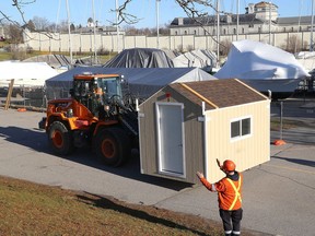 City of Kingston staff move a sleeping cabin into position at Portsmouth Olympic Harbour on Friday. Three cabins were delivered on Friday, with three more expected next week and four on Jan. 5.