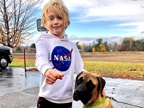 Eight-year-old Ciaran McIntyre with his eight-month-old English Mastiff, Abby, outside of his Glenburnie home on Wednesday