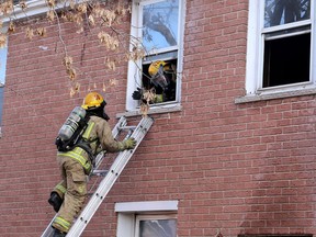 Kingston Fire and Rescue firefighters work to extinguish a fire at 213 Sydenham St. on Thursday