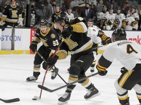 Kingston Frontenacs forward Martin Chromiak gets a shot off as Hamilton Bulldogs defenceman Lucas Moore moves in to check him during Ontario Hockey League action at the Leon's Centre on Friday.