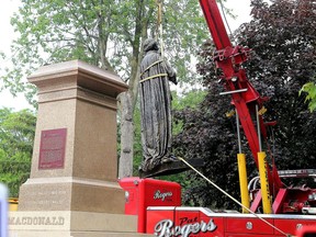 Work crews in the process of removing the statue of Sir John A. Macdonald from City Park in Kingston on June 18.