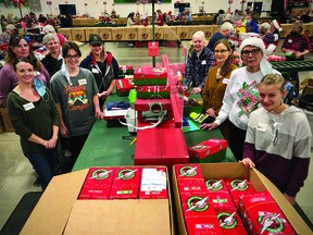 Nine Nanton residents, led by Brittany Riddle, front left, spent Dec. 2 in Calgary inspecting Operation Christmas Child gift-filled shoeboxes at the headquarters of Samaritan's Purse.