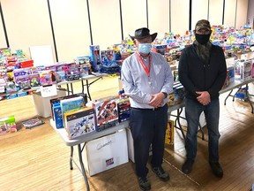 Marcel Marsan (left), is the longtime supervisor of the toy collection area at the former Thee Place and Kiwanian Chris McArton has been his assistant for the past five years. They and a team of volunteers are responsible for cataloguing and sorting the toys and packing the toys for the 90 families which will be assisted by the Kiwanis Christmas Toy and Food Drive this year.