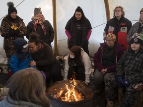 Students gather around a fire at a land-based learning camp outside of Anzac, Alta. on Friday, December 3, 2021. Photo courtesy Robert Murray