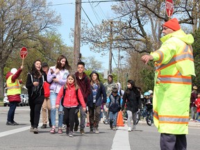 Crossing guards Pauline Carr, left, and Gary Cooper help students at Errol Road Public School cross Indian Road in 2019. Sarnia city council has reapproved curb bump-outs for the Indian and Errol roads intersection. (Tyler Kula/Sarnia Observer)