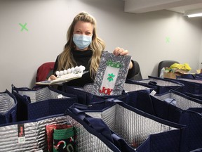 Amy Weiler, community engagement specialist with Lambton Elderly Outreach, helps pack holiday gift bags for clients of the agency providing services to older adults and adults with disabilities.