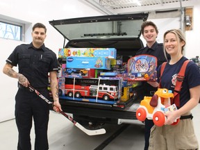 Point Edward firefighters, from left, Trayce Shaw, Gavin Burgess and Justine Davies stand next to one of two trucks loaded with toys donated to the Point Edward Fire and Rescue's annual Santa's First Responders' toy drive. They were delivered this week to St. Clair Child and Youth Services and Bluewater Health.
