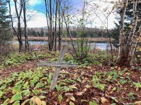 A faded wooden cross leans in the old cemetery at Burwash, where an industrial farm operated for many years. A large block of land is now for sale at the site of the former correctional facility and related ghost town, although the cemetery itself does not appear to be part of the package. Jim Moodie/Sudbury Star