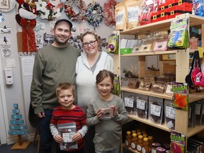 Phil and Linda Pigeau, of P.L. Bargain Deals at 2008 Lasalle Blvd., show a section of their store with the help of their children, Alexandre, 4, and Abigail, 6.