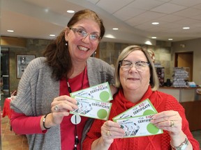 Shelley Ambroise (left) and Leona Allen, with Tourism Sarnia-Lambton, hold Discovery Sarnia-Lambton gift cards, redeemable at 300 restaurants, stores and other local businesses. The cards are included in gift package prizes being offered during the agency's Twelve Days of Christmas Giveaways promotion. Paul Morden/Postmedia