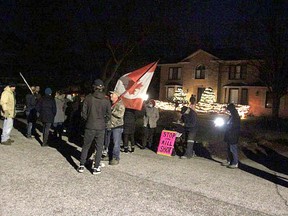 About 50 people gathered in front of what they said is Sarnia-Lambton medical officer of health Dr. Sudit Ranade's home on the evening of Dec. 14 to protest COVID-19 vaccine and masking requirements. Tyler Kula/Postmedia