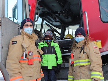 Anthony Bedard, 6, climbs aboard a Timmins fire truck that was on display during the Holiday Fun Day event held Saturday afternoon. The youngster is seen here accompanied by Travis Tulloch, a full-time firefighter with Timmins fire department, and Emilie Ratte, a Timmins fire volunteer.

RON GRECH/The Daily Press