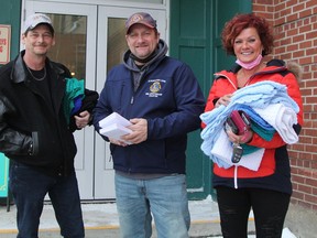 Schumacher Lions Club members Derek Thibeault, left, and Glen Guacci were delivering Stan Fowler Santa Claus Fund grocery vouchers and scarves Saturday morning along with volunteer driver Faith Bourgeois.

RON GRECH/The Daily Press