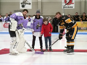 Hunter Hambleton, with his father Ryan, drops the puck Saturday night during a Hockey Fights Cancer pre-game ceremony. Taking the faceoff are Tillsonburg Thunder goalie Andre Roy (left) and Alvinston Killer Bees' Justin Lightfoot. Ryan's dad, Dan Hambleton (1959-2010), was the original Thunder GM. (Chris Abbott/Norfolk and Tillsonburg News)