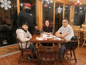 Patrick McMahon, co-owner of The Mill Eatery on John Pound Road (standing), hosted a Pay What You Can Christmas day meal. The Dhiman family of Tillsonburg was one of many families enjoying a full Christmas dinner in the restaurant. (Chris Abbott/Norfolk and Tillsonburg News)