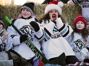 Players with the Woodstock Wildcats hockey association wish the crowd a "Merry Christmas" Sunday during the city's Santa Claus Parade.
BRUCE URQUHART/SENTINEL-REVIEW