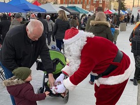 A toddler receives a candy gift from Santa Claus during the Rodney Night Market, held Dec. 4. Handout