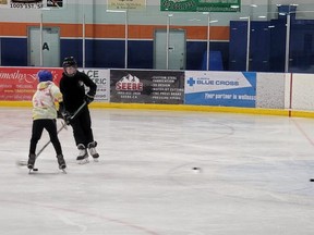 Two hockey players playing drop-in shinny on Jan. 4 at the Bob Snodgrass Recreation Complex.
