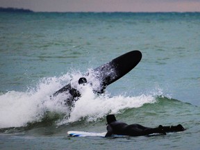A winter surfer wipes out on a large swell in Lake Ontario waters off Presqu'ile Provincial Park as another surfer paddles nearby. High winds created perfect conditions for cold-water surfing along the park's beaches. DEREK BALDWIN