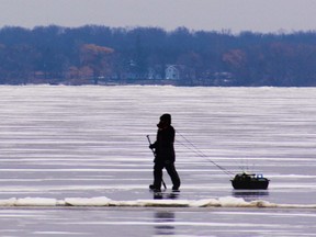 A lone angler walks along a large pressure crack in the ice on the Bay of Quinte off the hamlet of Point Anne east of Belleville early Wednesday morning. Ice huts are popping up on the bay as the winter freeze sets in and ice cover thickens. DEREK BALDWIN
