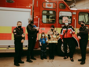 Cecily poses with the Fort Saskatchewan Fire Department team. Photo by A. Keen Photography.