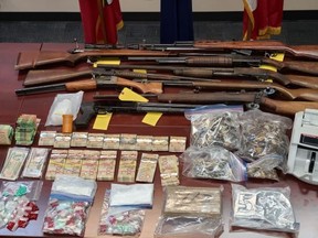 Provincial police seized firearms, cash and drugs after searches in South Middlesex and West Elgin, police say. Two Newbury men, aged 37 and 39, face gun- and drug-related charges (OPP supplied photo)