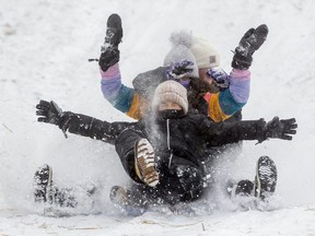 Lyla Conron, front, Talya Khanna and Ella Tomzincic, all 12, are a riot of arms, legs and frozen faces as they come down a toboggan hill in Doidge Park. Outdoor amenities like that go a long way to help cities protect themselves from viruses like COVID-19, say two Western University researchers. (Mike Hensen/The London Free Press)