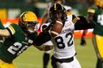 Edmonton Elks’ Jordan Hoover (28) tackles Hamilton Tiger-Cats’ Steven Dunbar Jr. (82) during first half CFL action at Commonwealth Stadium in Edmonton, on Friday, Oct. 29, 2021. Hoover and the club came to an agreement on a one-year contract for next season.