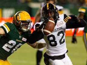 Edmonton Elks’ Jordan Hoover (28) tackles Hamilton Tiger-Cats’ Steven Dunbar Jr. (82) during first half CFL action at Commonwealth Stadium in Edmonton, on Friday, Oct. 29, 2021. Hoover and the club came to an agreement on a one-year contract for next season.