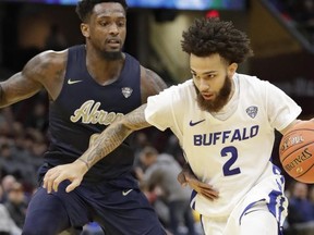 Buffalo's Jeremy Harris (2) drives past Akron's Jimond Ivey (0) during the first half of an NCAA college basketball game at the Mid-American Conference tournament, Thursday, March 14, 2019, in Cleveland.