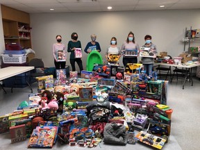 Leduc Santa's Helpers volunteers show off a pile of toys raised from one of the organization's many toy drives this Christmas season. (Leduc Santa's Helpers)