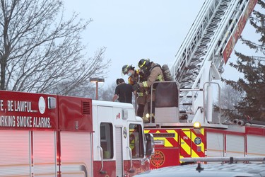 Firefighters help a man rescued from a sixth-floor apartment fire at 77 Allard St., in Sault Ste. Marie, Ont., on Friday, Jan. 21, 2022. (BRIAN KELLY/THE SAULT STAR/POSTMEDIA NETWORK)