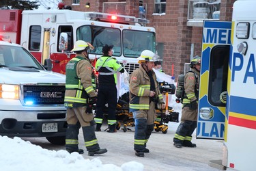 Fire at sixth-floor apartment at 77 Allard St., in Sault Ste. Marie, Ont., on Friday, Jan. 21, 2022. Rescued resident is at front of fire truck. (BRIAN KELLY/THE SAULT STAR/POSTMEDIA NETWORK)