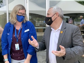 Science North staff scientist Amy Henson, left, chats with Nickel Belt MP Marc Serre.