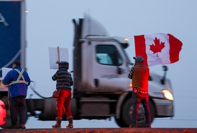 Supporters of the “freedom convoy” of truckers wait for the convoy along the Trans-Canada Highway east of Calgary on Monday, January 24, 2022. The truckers are driving across Canada to Ottawa to protest the federal government’s COVID-19 vaccine mandate for cross-border truckers.

Gavin Young/Postmedia