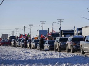 Truckers protesting a COVID-19 vaccine mandate for those crossing the Canada-U.S. border are seen on the Trans-Canada Highway west of Winnipeg earlier this week. DAVID LIPNOWSKI/THE CANADIAN PRESS