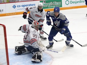 Marc Boudreau, right, of the Sudbury Wolves, looks for a rebound in front of goalie Zachary Paputsakis, of the Oshawa Generals, during OHL action at the Sudbury Community Arena in Sudbury, Ont. on Friday January 21, 2022.