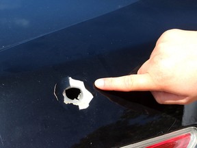 A resident of Laurentia Drive in Tilbury, who did not want to be named, points to a bullet hole in her vehicle following a police shooting Sept. 5, 2020, that injured a Tilbury man. Ontario's Special Investigations Unit said Tuesday a Chatham-Kent police officer acted reasonably in firing four shots at the man after he refused to drop the crowbar he was carrying, was tasered and then pulled out an object from his jacket and pointed it at officers. The object turned out to be a cordless screwdriver, the SIU said. Ellwood Shreve/Chatham Daily News/Postmedia Network