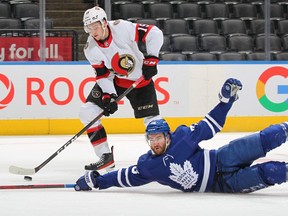 Drake Batherson (19) of the Ottawa Senators gets set to fire a puck away from a falling T.J. Brodie (78) of the Toronto Maple Leafs during an NHL game at Scotiabank Arena on Jan. 1, 2022, in Toronto, Ontario. (Photo by Claus Andersen/Getty Images)