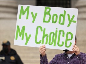 A person holds up a sign as people hold a rally in support of a group of 10 teachers fighting enforcement of the coronavirus (COVID-19) vaccine mandate for public school employees at Thurgood Marshall United States Courthouse on October 12, 2021 in New York City.