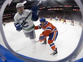 Vancouver Canucks' Reid Boucher (24) battles Edmonton Oilers' Matthew Benning (83) during the third period at Rogers Place in Edmonton on Saturday, March 18, 2017. (Photo by David Bloom)