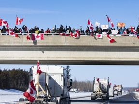 Supporters of truckers protesting the Canadian government’s vaccine mandate for cross-border truckers gather on the Dilworth Road Highway 416 overpass as the convoy makes its way to Ottawa on Friday, Jan. 28, 2022.